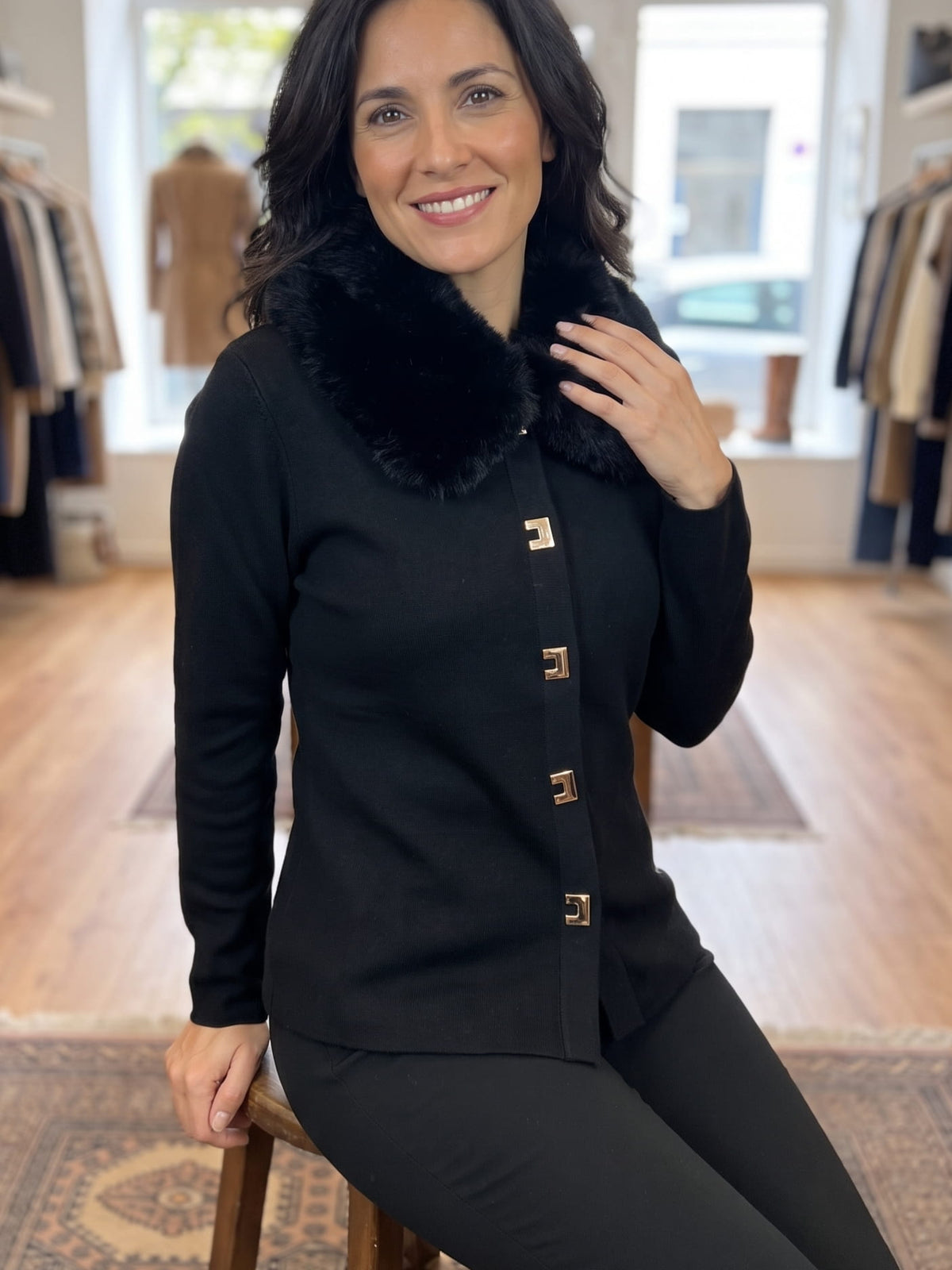 Rebeca de punto negra con cuello de pelo sintético y botones joya